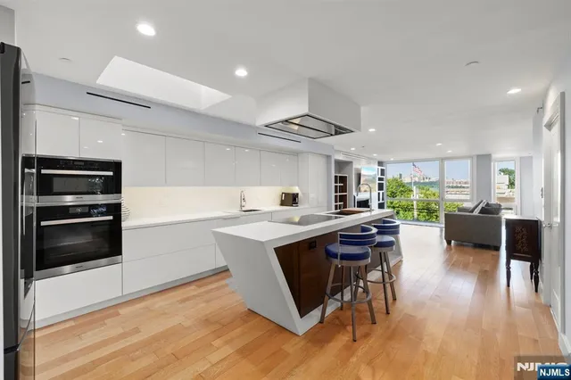 a kitchen with stainless steel appliances kitchen island a sink and refrigerator