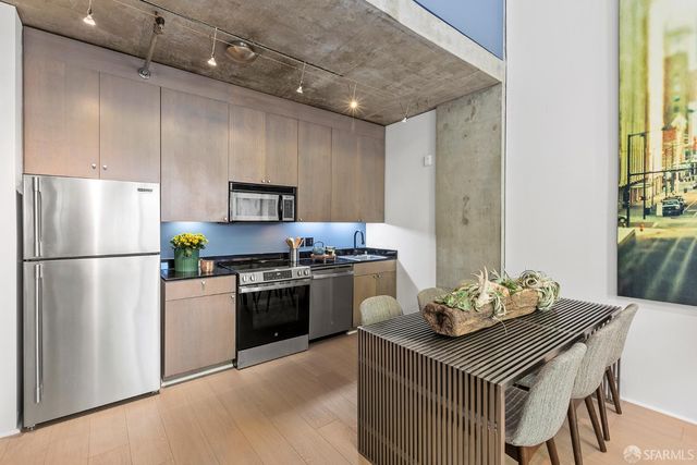 a kitchen with a refrigerator a stove a sink and a dining table