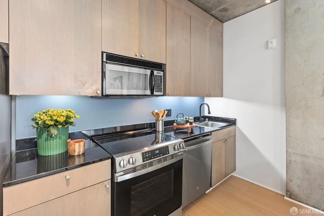 a kitchen with stainless steel appliances granite countertop a sink stove and cabinets