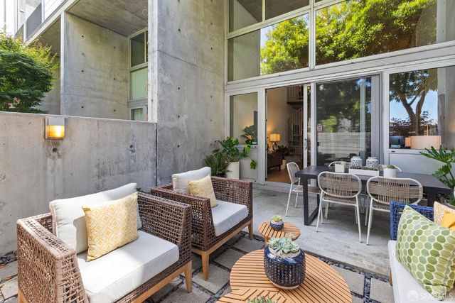 a view of a patio with couches table and chairs and potted plants