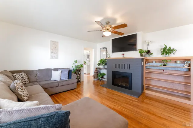 a living room with furniture a fireplace and a flat screen tv