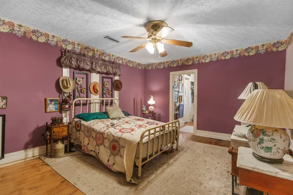 a bedroom with a bed a bookshelf and piano