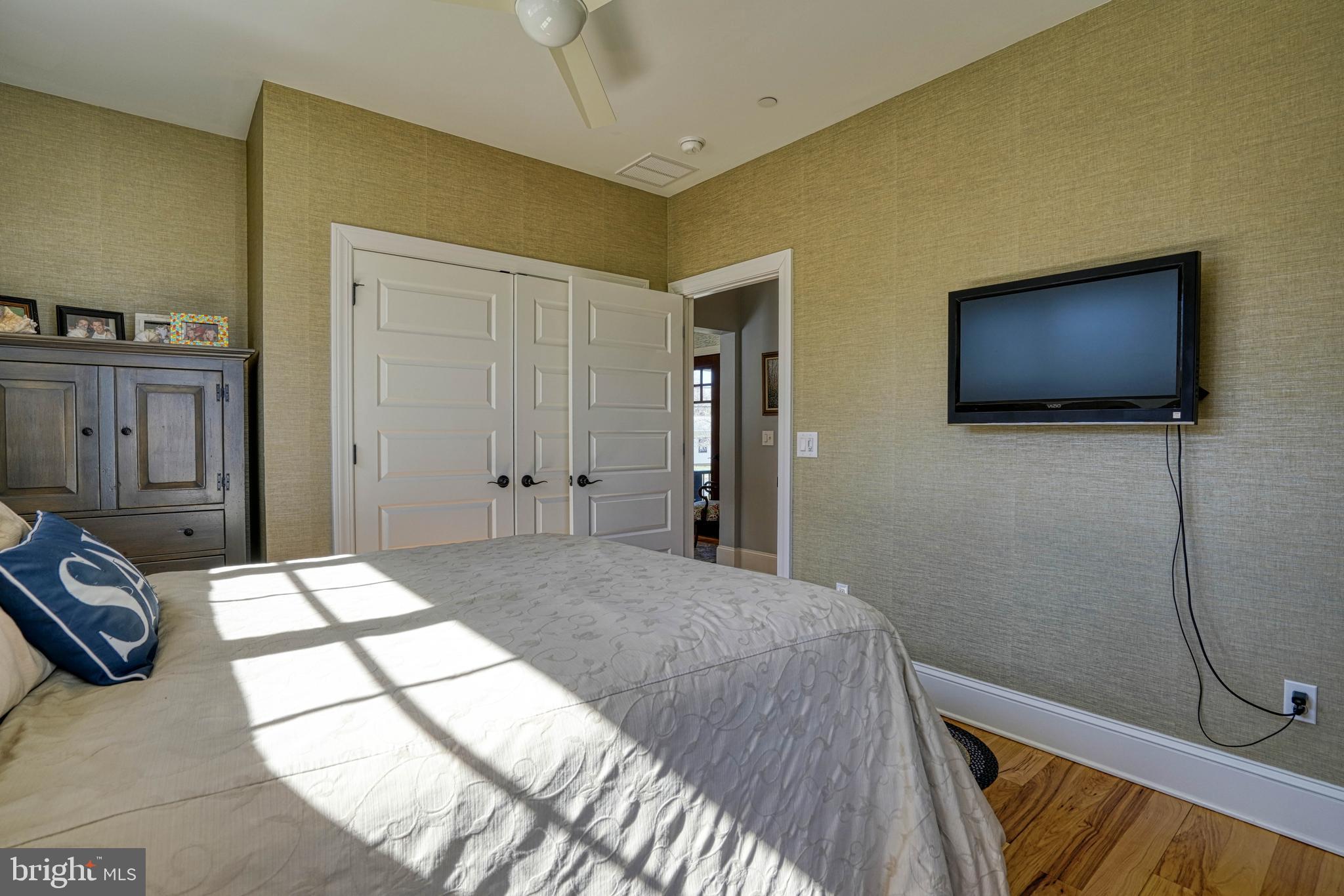 303 Manor Street St. Michaels, MD 21663 - Photo 60 of 100 a spacious bedroom with a bed and a flat screen tv