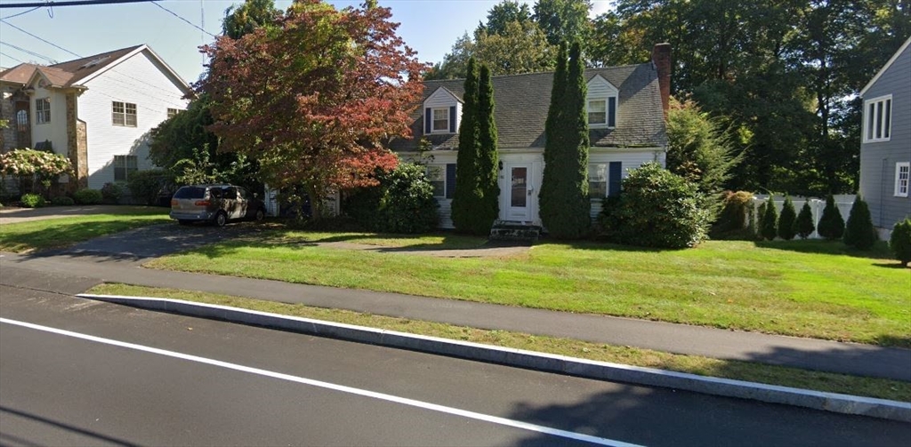 a view of a house with a yard and large trees