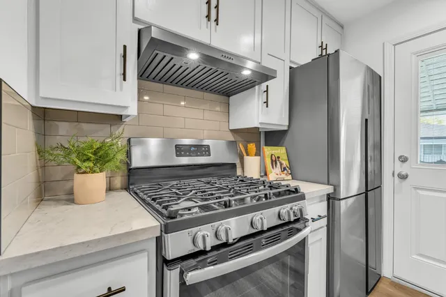 a kitchen with a refrigerator and a stove
