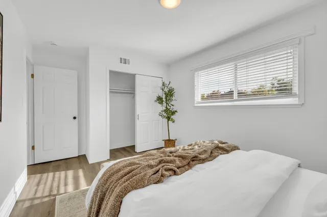 a bedroom with a bed and a potted plant
