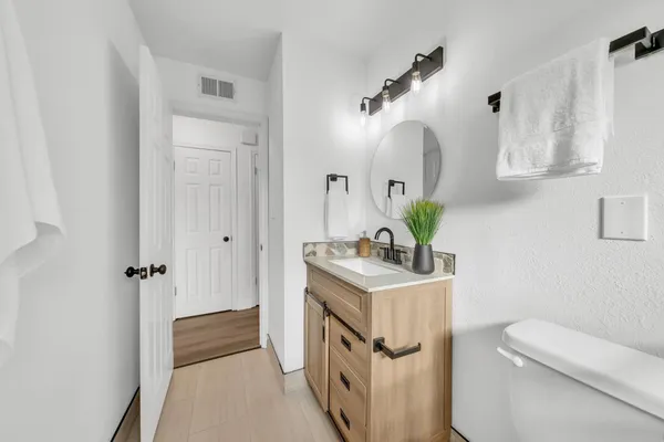 a bathroom with a sink a toilet and a mirror