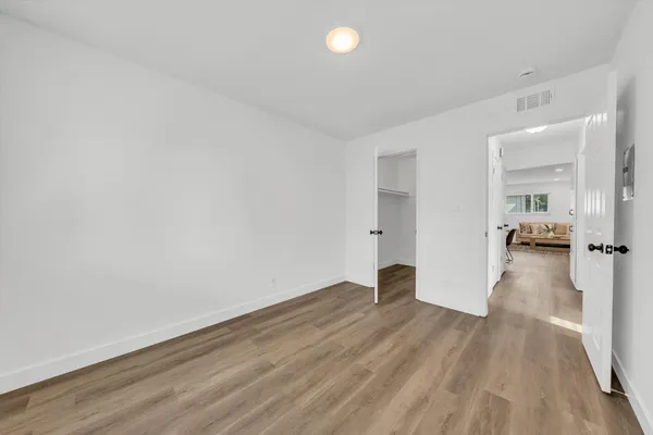 a view of a big room with wooden floor and a bathroom