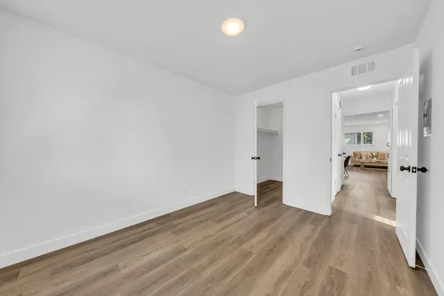 a view of a big room with wooden floor and a bathroom