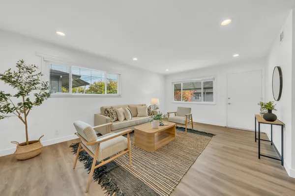 a living room with furniture and a wooden floor
