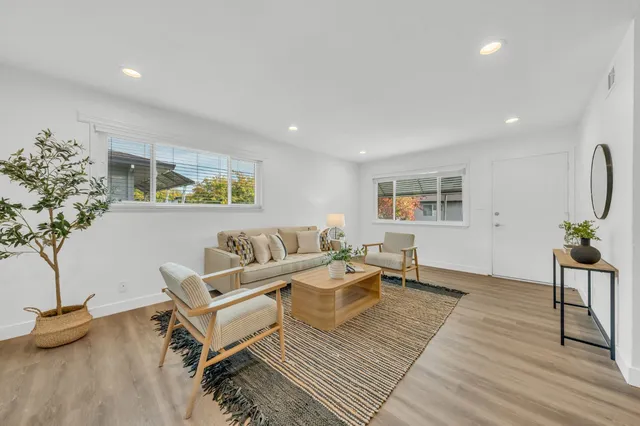 a living room with furniture and a wooden floor
