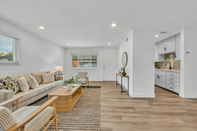 a living room with furniture and wooden floor
