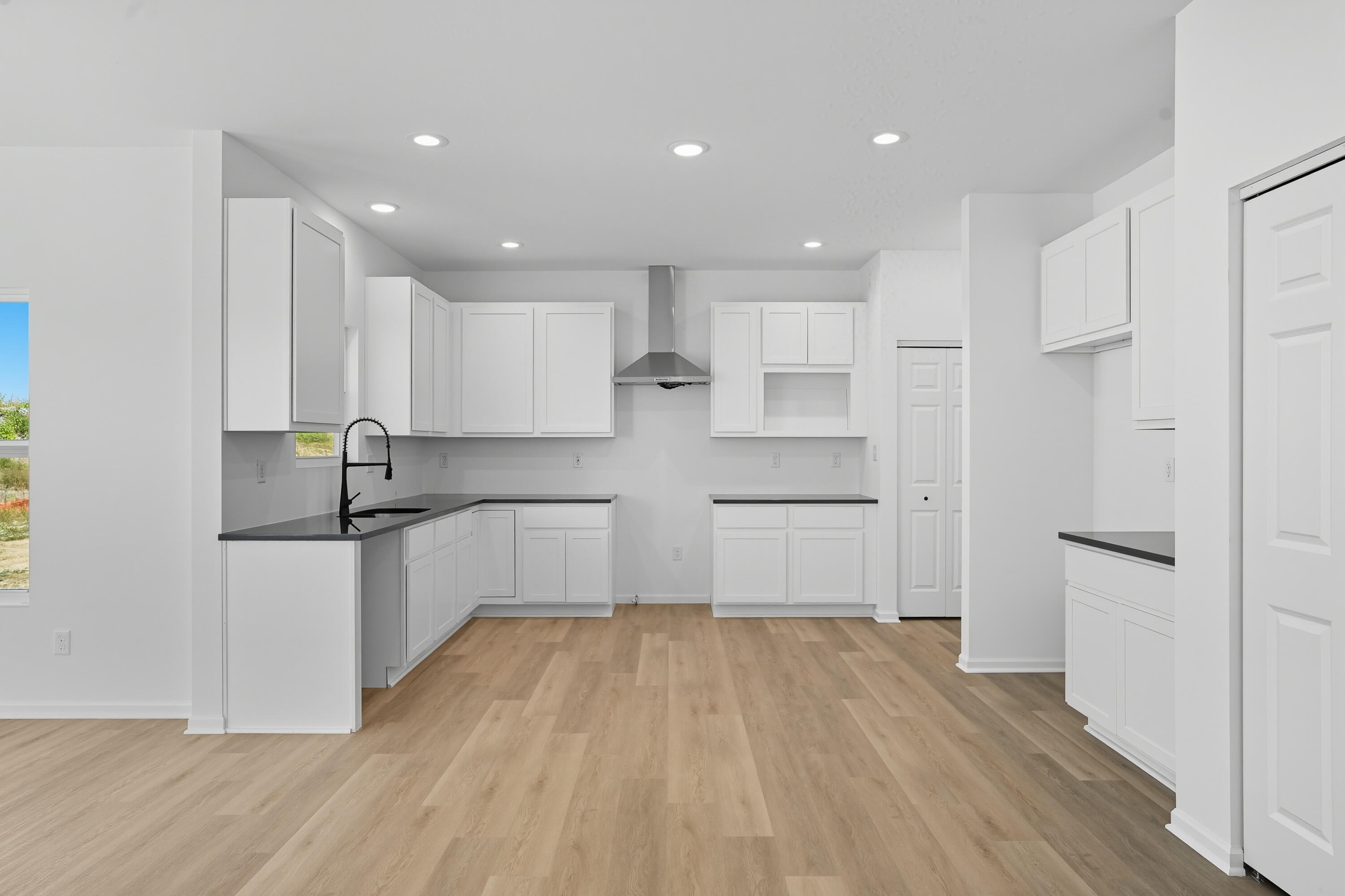 5800 Buck Lane Portage, IN 46368 - Photo 6 of 22 a kitchen with white cabinets and wooden floor