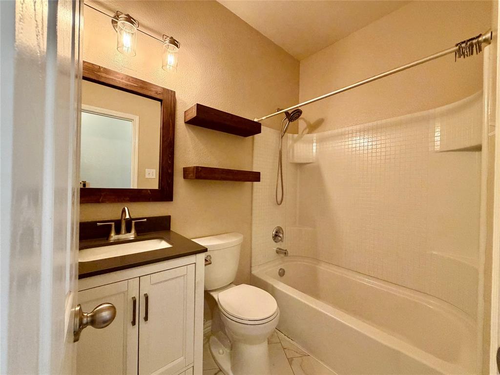 5817 Deck House Road Fort Worth, TX 76179 - Photo 12 of 19 Bathroom featuring a white vanity with dark countertop, undermount sink, and brushed nickel faucet