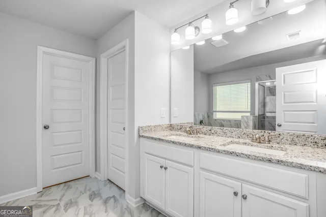 a bathroom with a granite countertop sink and a mirror