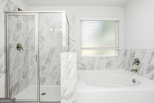 a white bath tub sitting next to a shower