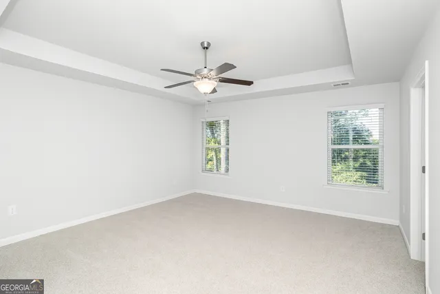 an empty room with a window and a fan