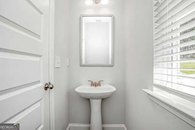 a bathroom with a sink a mirror and a window