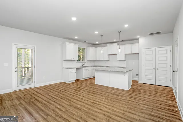 a large kitchen with kitchen island a sink stainless steel appliances and cabinets