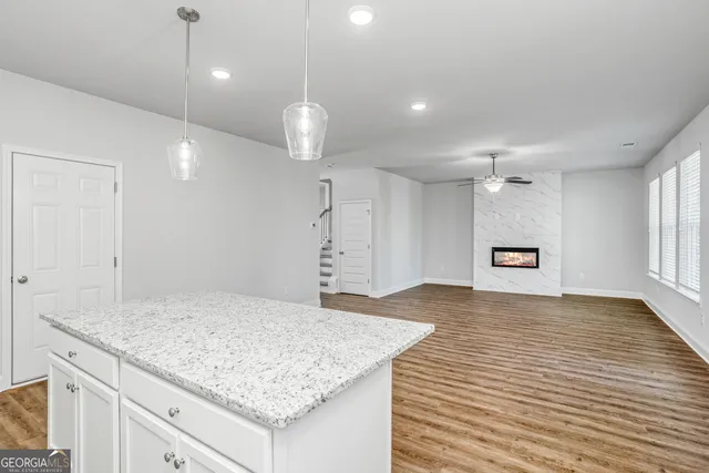 an empty room with kitchen appliances and wooden floor