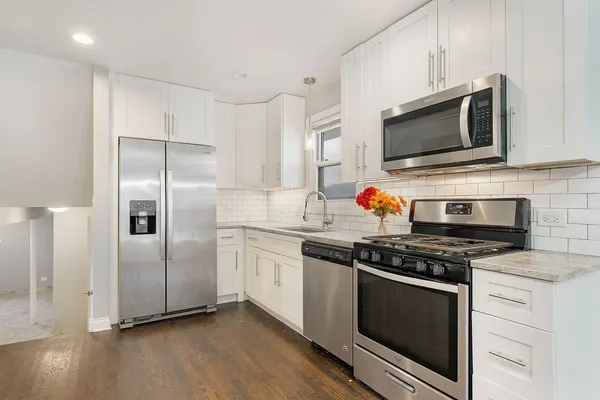 a kitchen with stainless steel appliances granite countertop a stove microwave and refrigerator