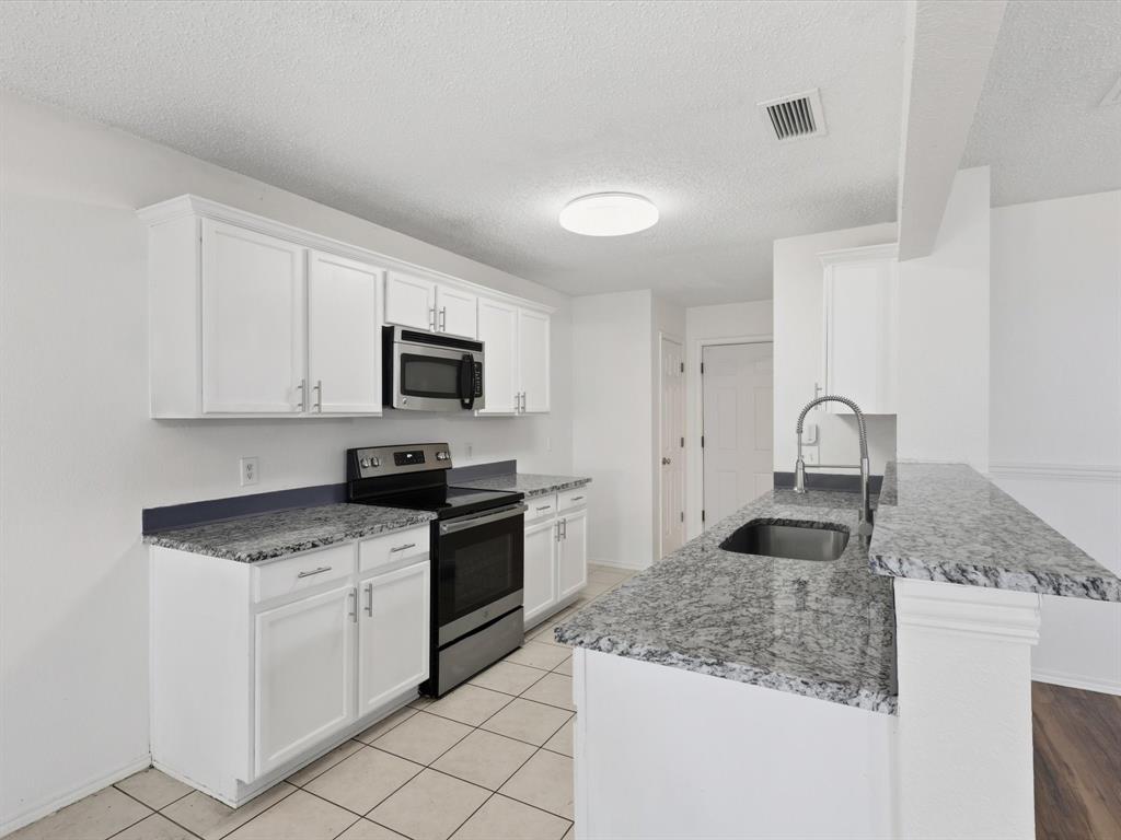 4305 Falcon Drive Sherman, TX 75092 - Photo 11 of 27 a kitchen with granite countertop white cabinets and appliances