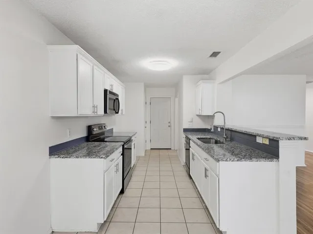 a kitchen with a sink stove and cabinets