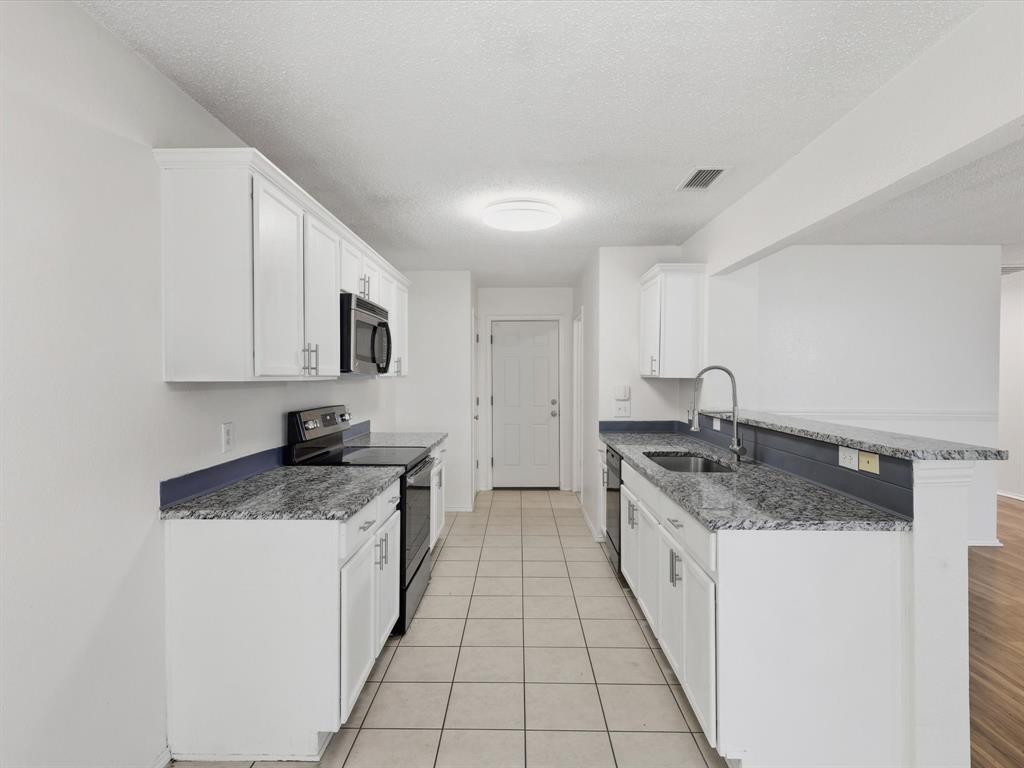 4305 Falcon Drive Sherman, TX 75092 - Photo 12 of 27 a kitchen with a sink stove and cabinets