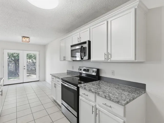 a kitchen with stainless steel appliances granite countertop a sink stove and microwave