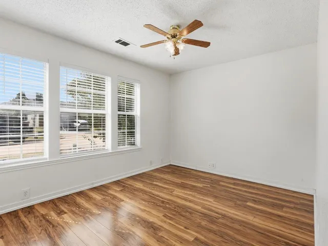 a view of a big room with wooden floor and a window