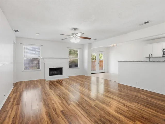 a view of empty room with wooden floor and fireplace