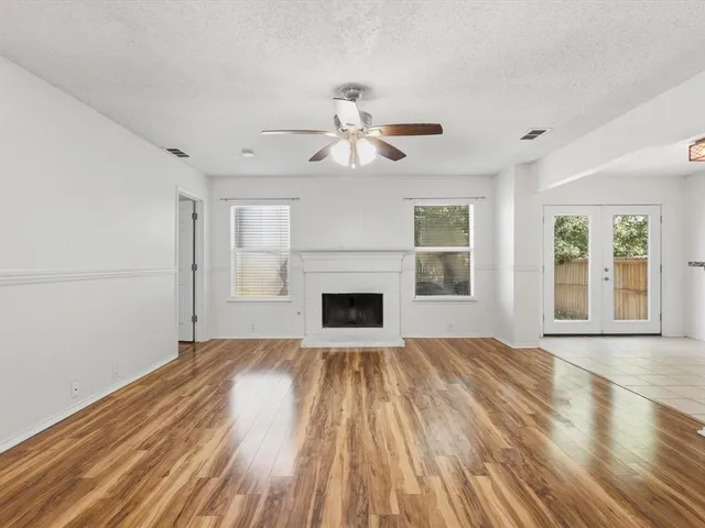 a view of empty room with fireplace and wooden floor