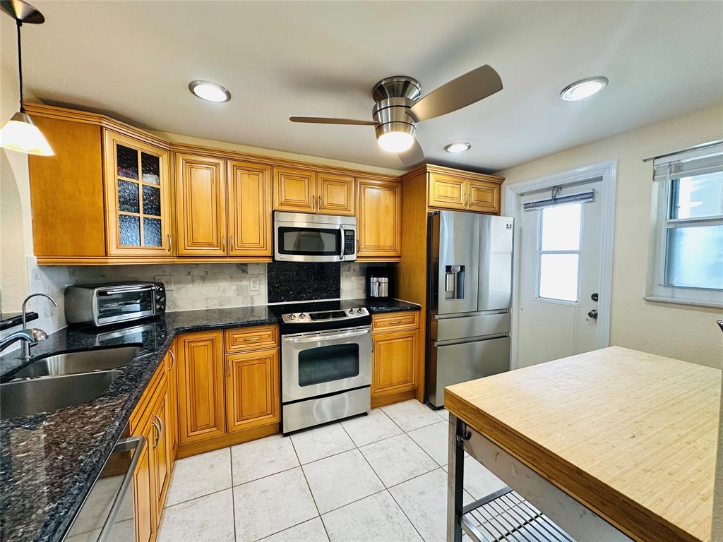 750 North Ocean Boulevard, Unit 2008 Pompano Beach, FL 33062 - Photo 17 of 64 a kitchen with stainless steel appliances granite countertop a sink a stove top oven a refrigerator with island and chairs