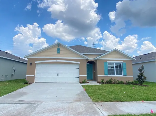 a view of a house with a yard and a garage