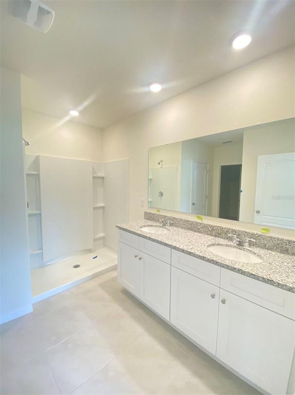 556 Talisi Loop St. Cloud, FL 34771 - Photo 13 of 16 a bathroom with a sink and a large mirror