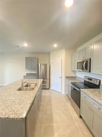 a kitchen with stainless steel appliances granite countertop a sink and dishwasher refrigerator stove with wooden cabinets