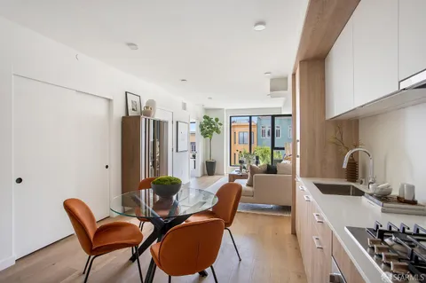 a view of a kitchen with furniture a sink and a refrigerator