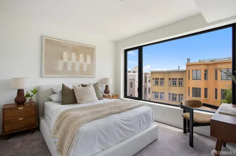 a bedroom with a bed and a large window