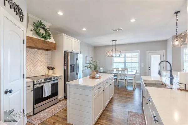 a large kitchen with stainless steel appliances lots of counter space and a sink
