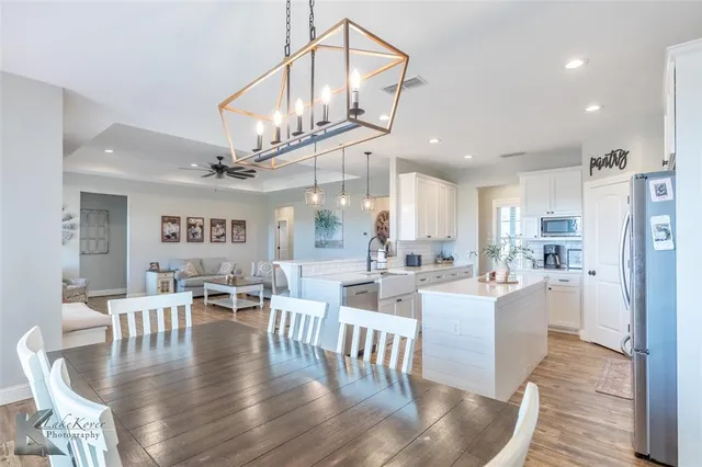 a dining room with lots of furniture and a chandelier