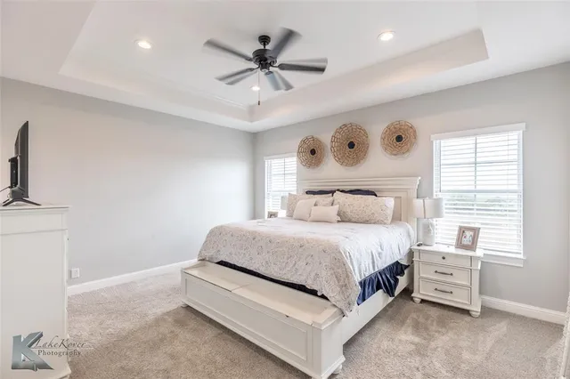 a spacious bedroom with a large bed and a chandelier