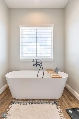 a white bath tub sitting in a bathroom next to a window