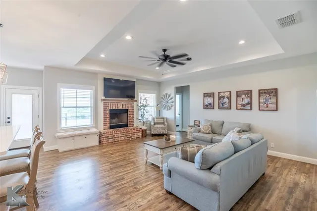 a living room with furniture a fireplace and wooden floor