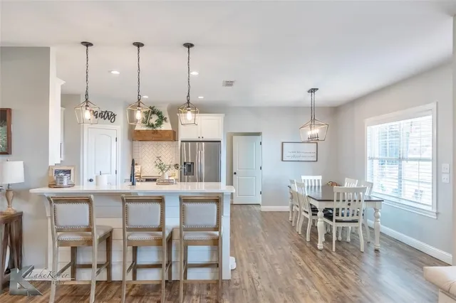 a dining room with furniture a chandelier and wooden floor