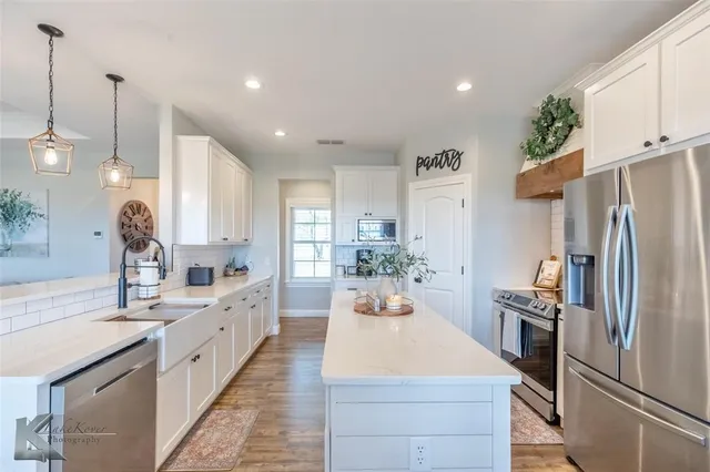 a large kitchen with kitchen island a sink stainless steel appliances and cabinets