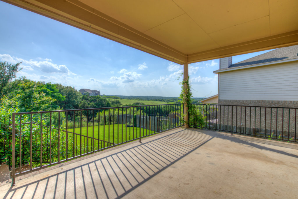 403 Limestone Trail Austin, TX 78737 - Photo 16 of 18 An inviting covered patio offering panoramic views of the verdant landscape and distant homes.