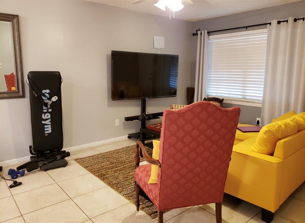 4876 Lake Ridge Road, Unit 5 Orlando, FL 32808 - Photo 5 of 11 a living room with furniture and a flat screen tv