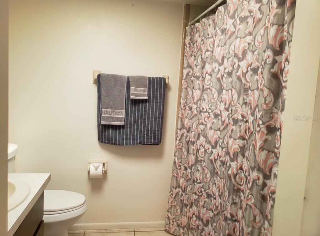 4876 Lake Ridge Road, Unit 5 Orlando, FL 32808 - Photo 8 of 11 a bathroom with a toilet and a shower curtain
