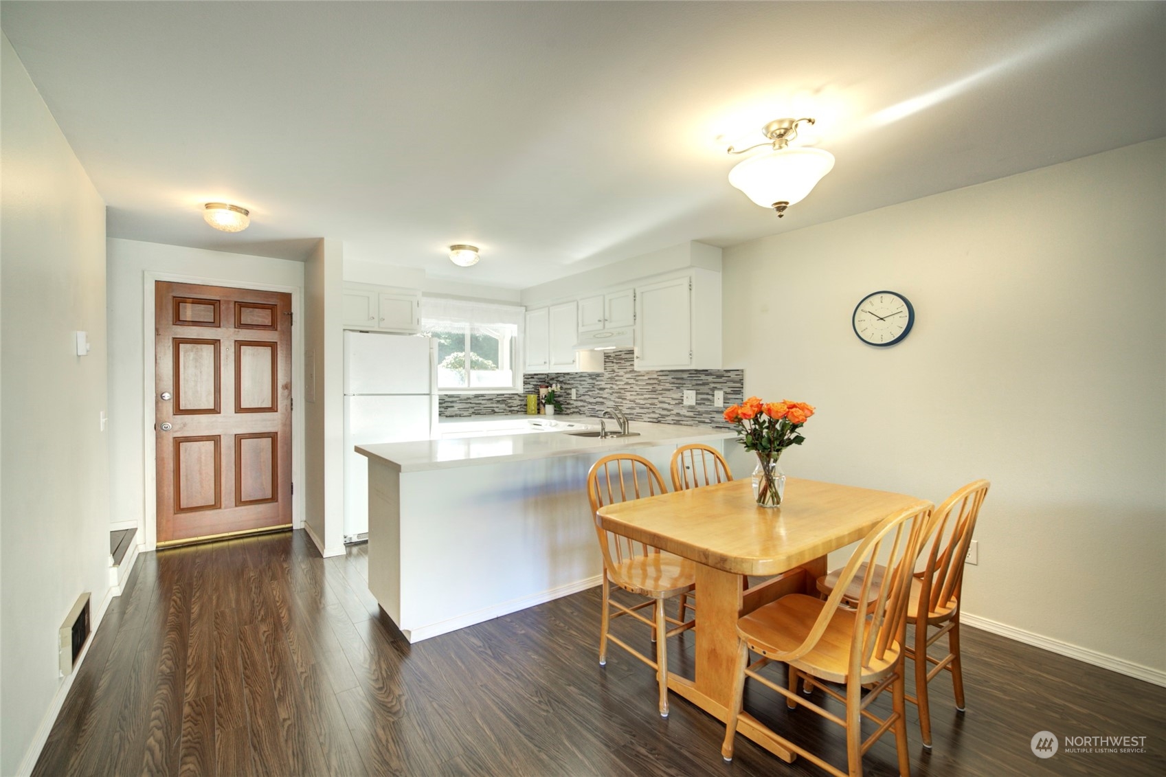 22906 Edmonds Way, Unit 15 Edmonds, WA 98020 - Photo 13 of 22 a dining room with wooden floor a chandelier a wooden table and chairs