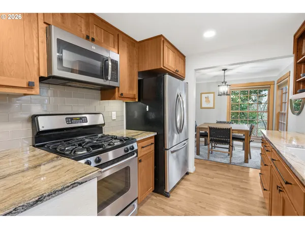 a kitchen with stainless steel appliances granite countertop a refrigerator stove and microwave